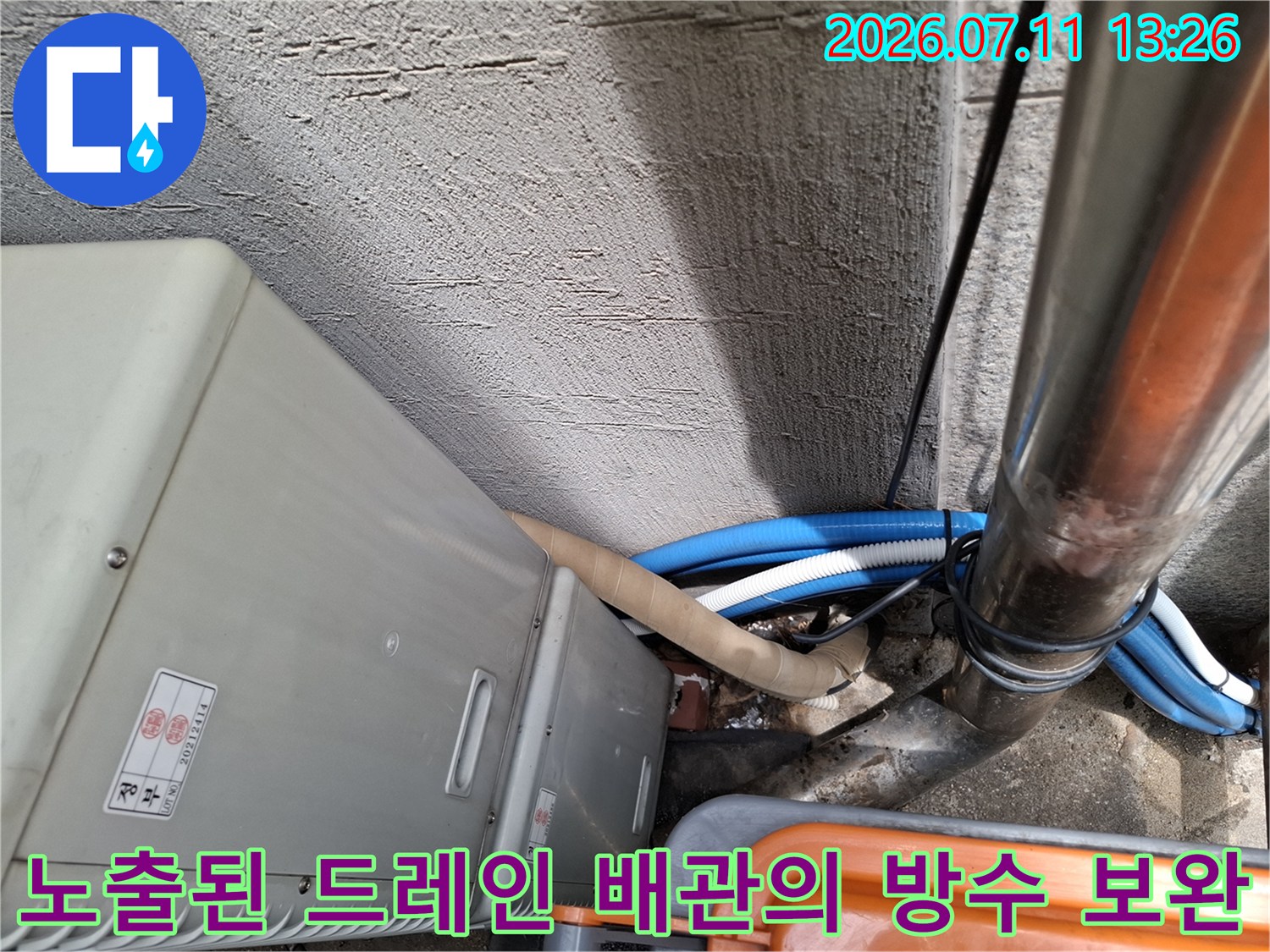 어두운 공간에서 파란색과 흰색 드레인 호스 연결 부위를 정밀하게 점검하는 현장 모습