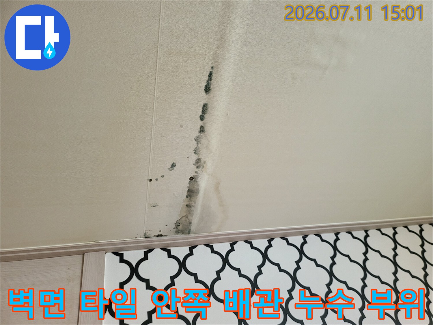 천장 마감재에 길게 남은 물줄기 흔적과 변색된 구간