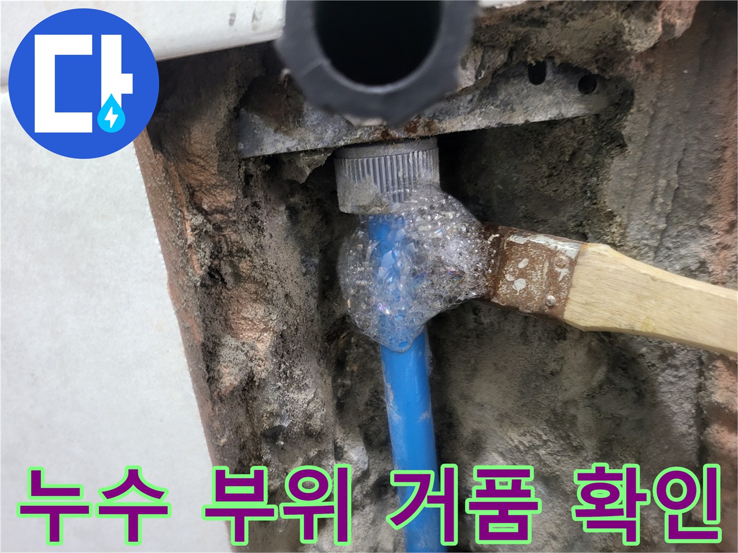 파란색 배관 연결 부속에 비눗물을 도포하여 누수를 확인하는 장면