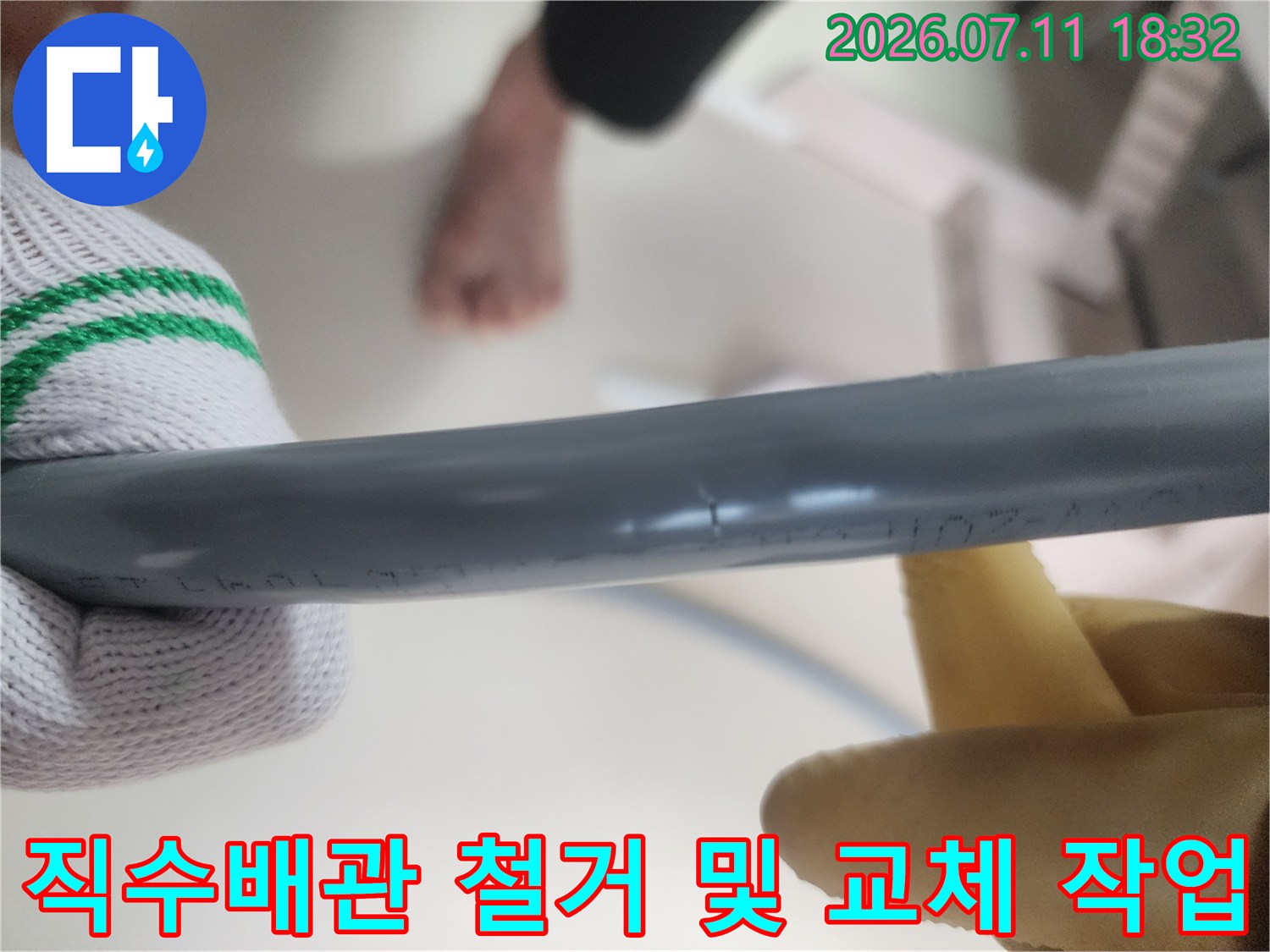 작업자가 장갑을 끼고 노출된 회색 직수배관을 점검하며 교체 작업을 준비하는 모습