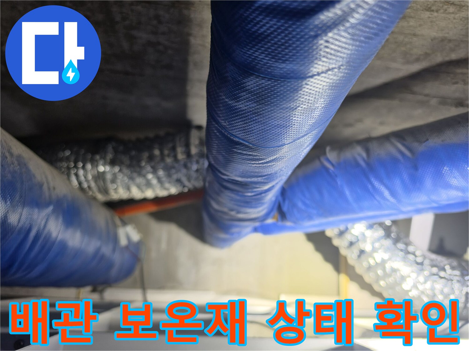 파란색으로 감싸진 배관과 은색 자바라가 얽혀 있는 천장 내부 모습