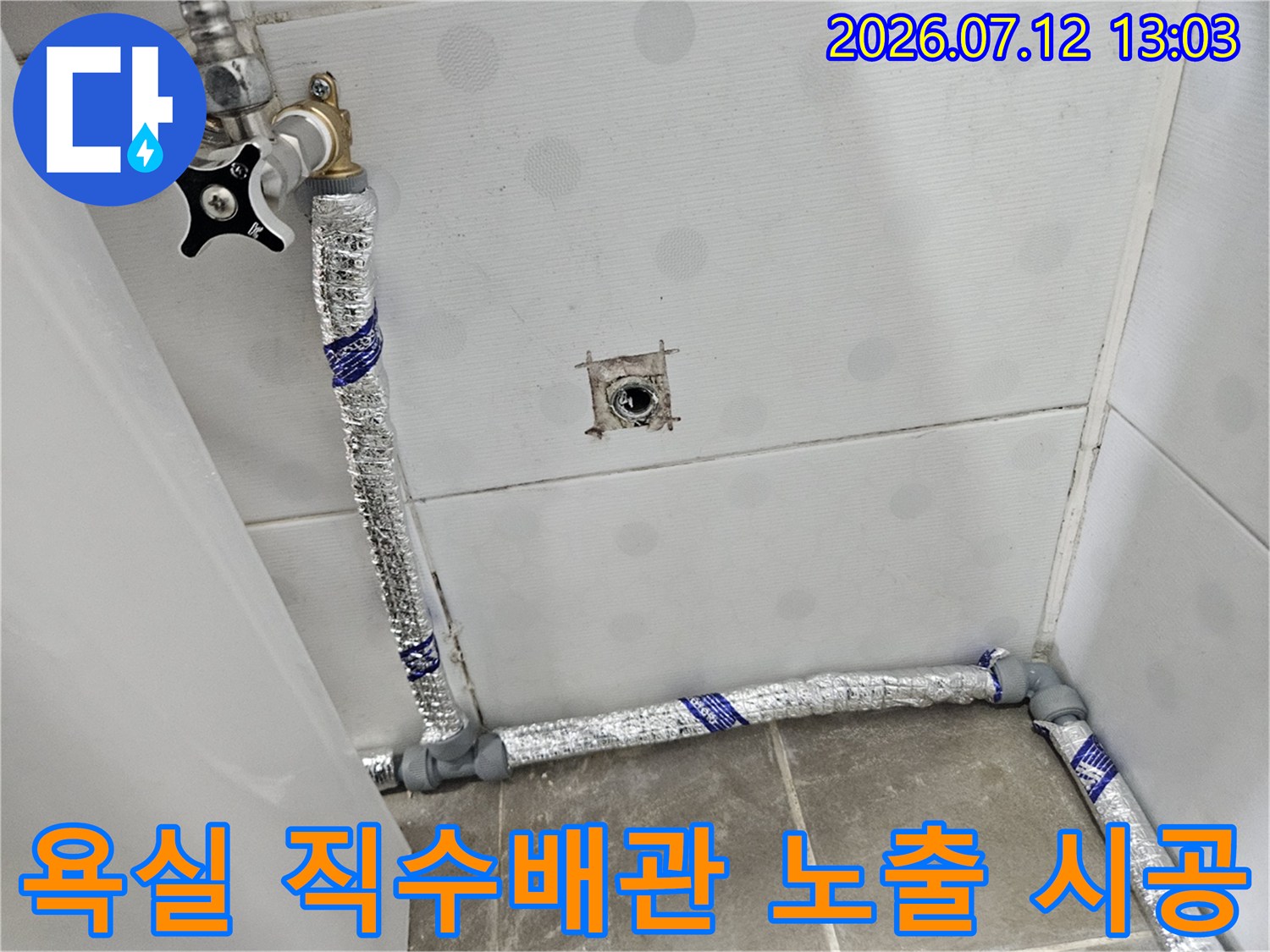 은색 보온재로 감싼 욕실 내 노출형 직수 배관과 밸브 연결 부위