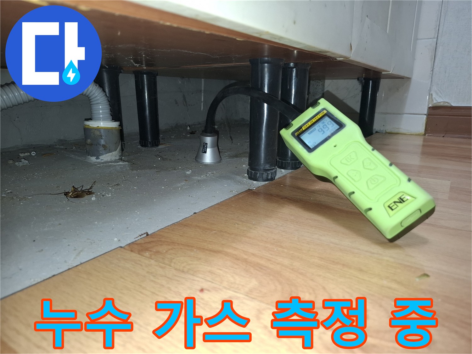 싱크대 아래 배관 주변에서 수치를 확인하는 가스 탐지기 모습