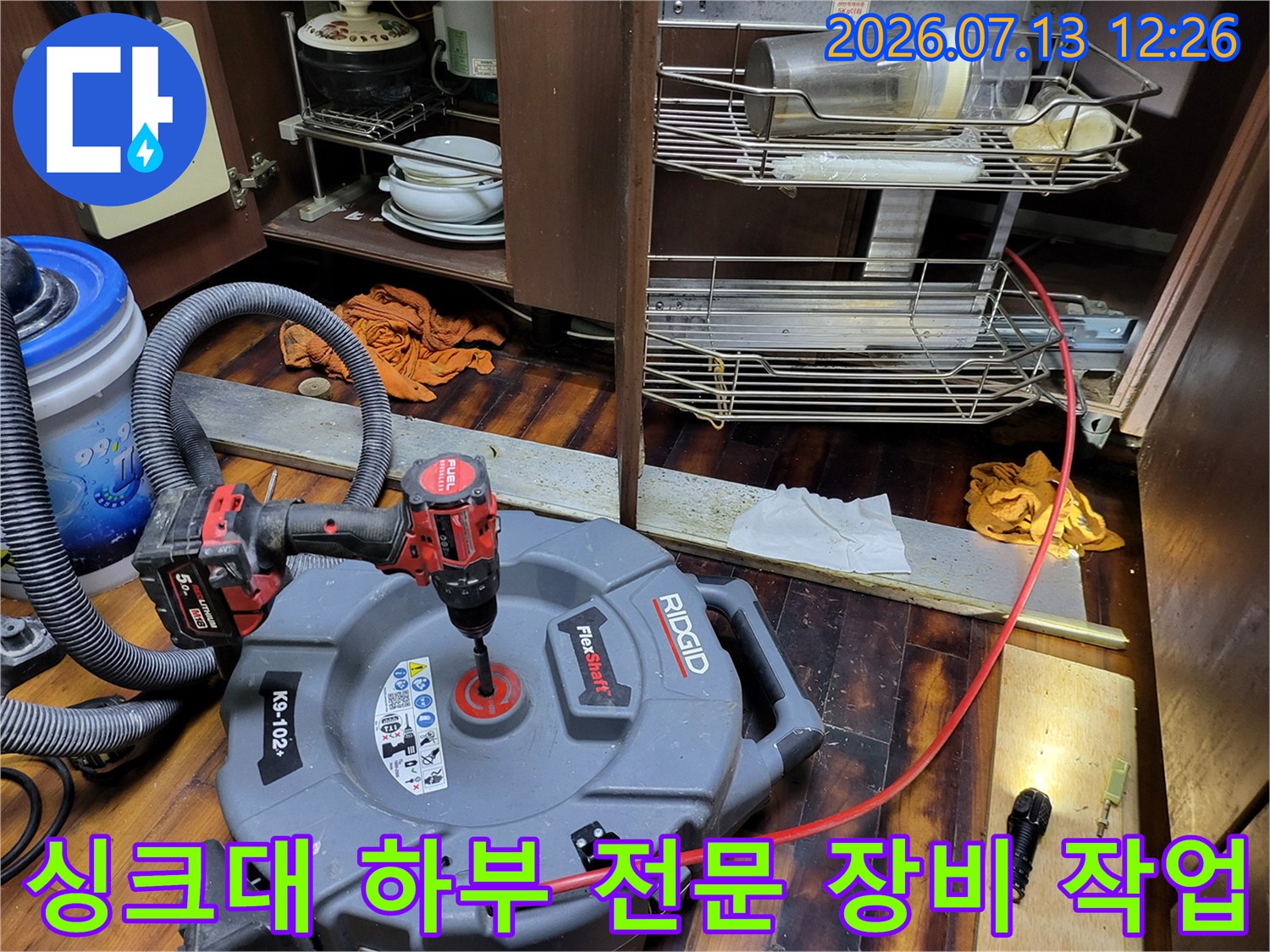 전문가용 대형 청소기가 싱크대 배관에 연결되어 세척을 진행 중인 모습
