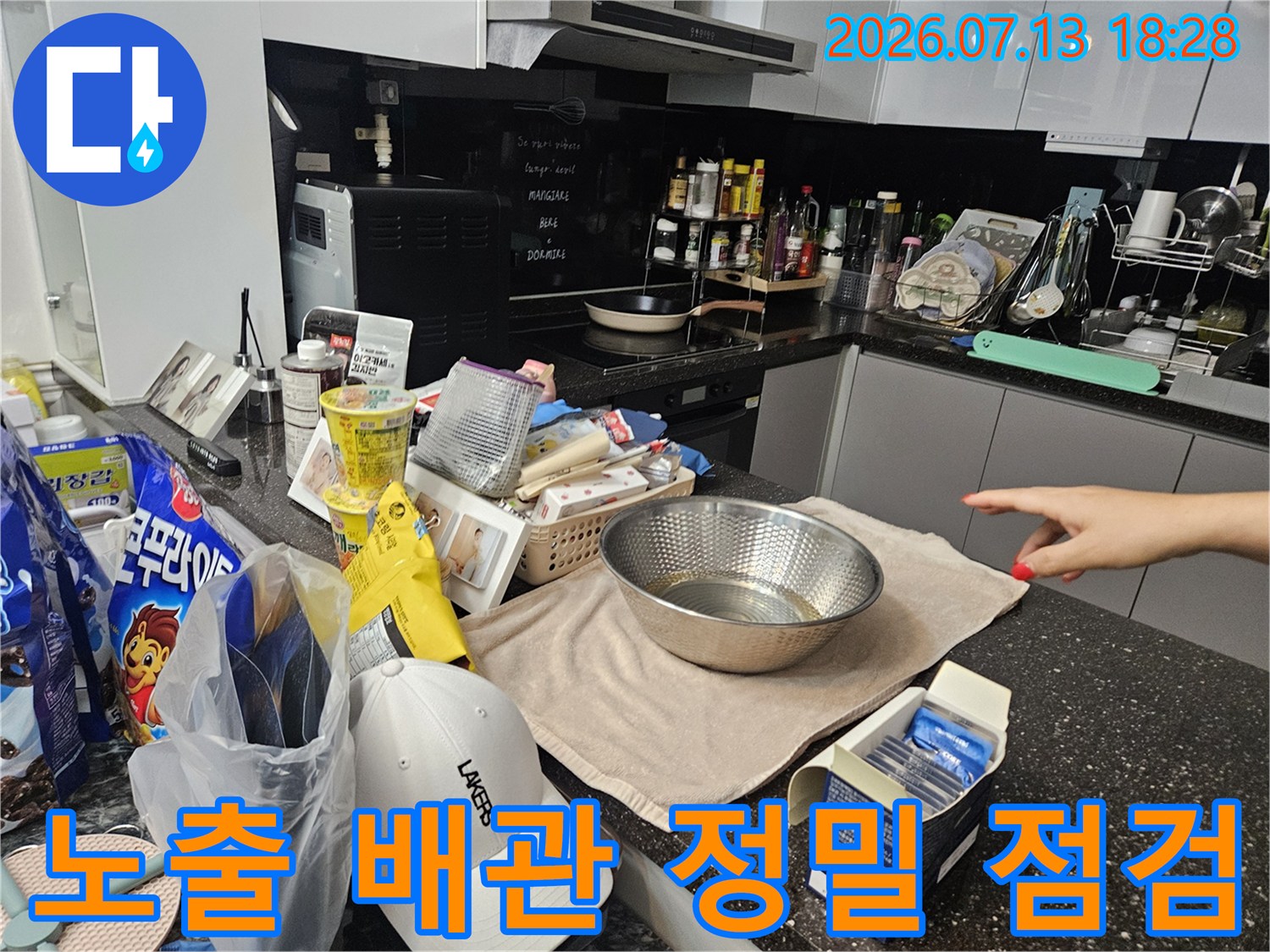 세탁실 내부에서 노출된 분배기 및 연결 부위를 전용 장비로 진단하는 장면