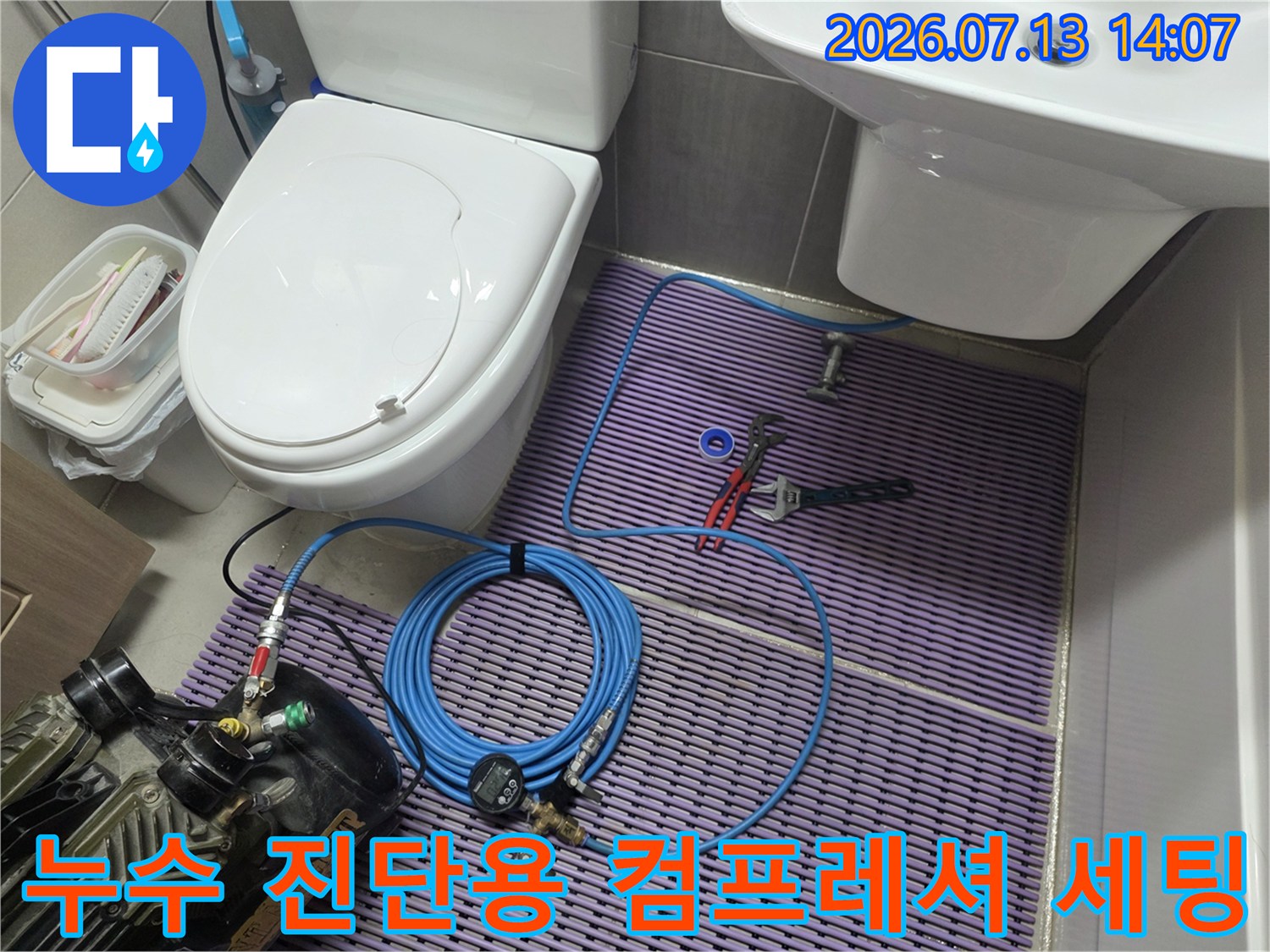 공압 검사 장비와 호스가 연결된 화장실 내부 배관 점검 모습