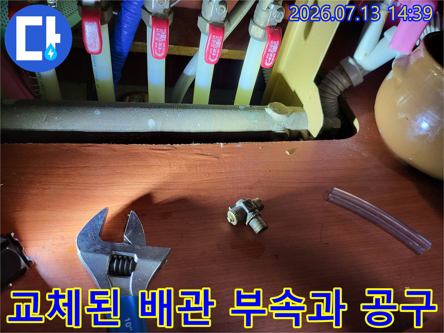보일러-분배기-앞에-놓인-교체용-금속-부속-그리고-몽키스패너와-투명-호스