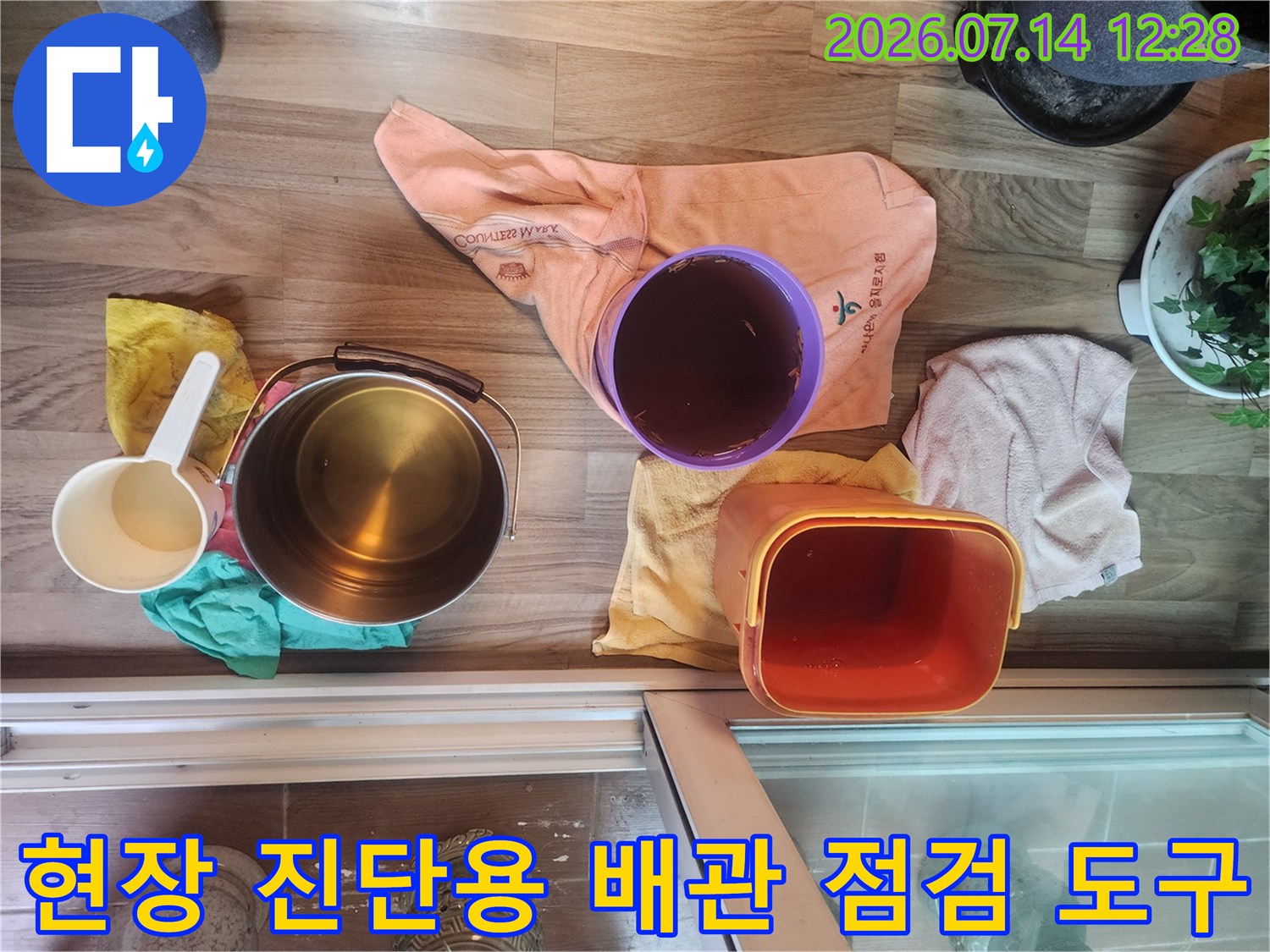 작업을 위해 배치된 다양한 크기의 양동이와 수거함-배관 공사 준비물
