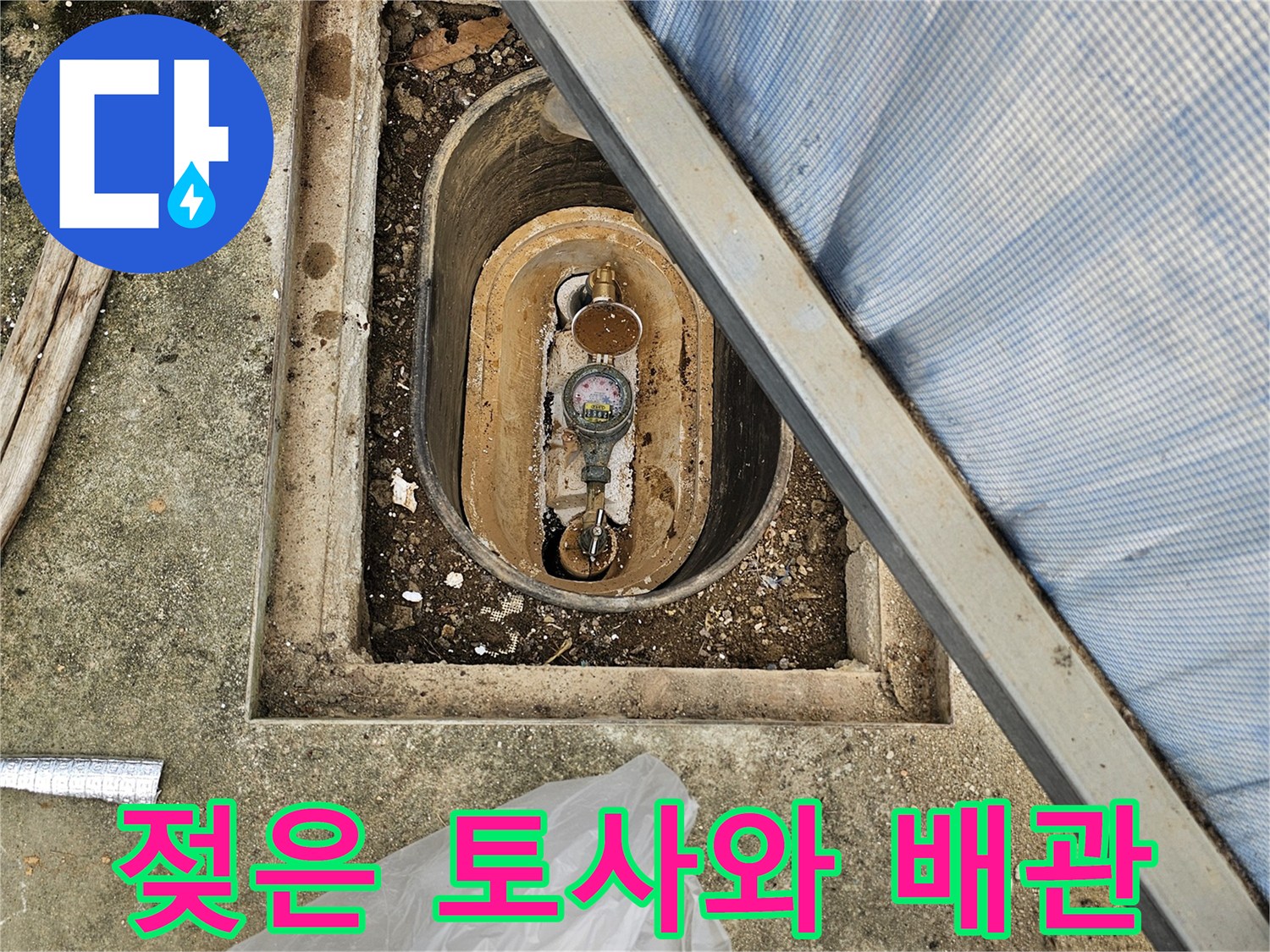 배관 연결부 주변 - 젖어 있는 흙과 계량기 부속품
