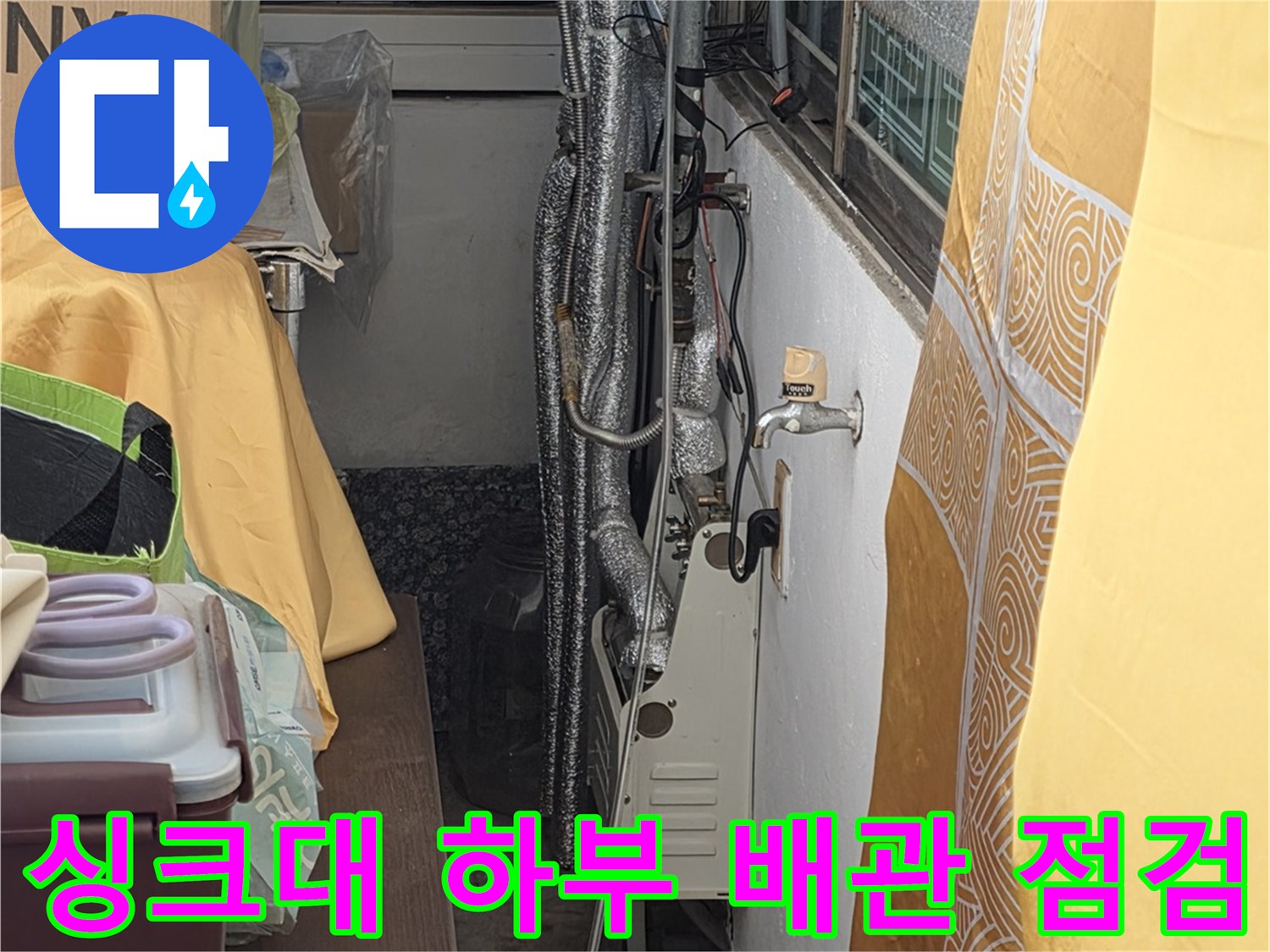 보온재로 덮인 싱크대 아래 수도 배관의 연결 부위