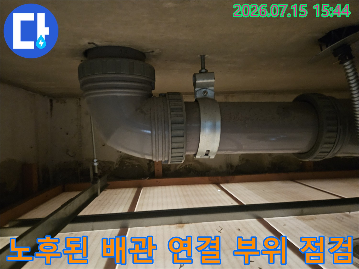 노후된 회색 플라스틱 배관과 금속 연결 부품의 상세 모습