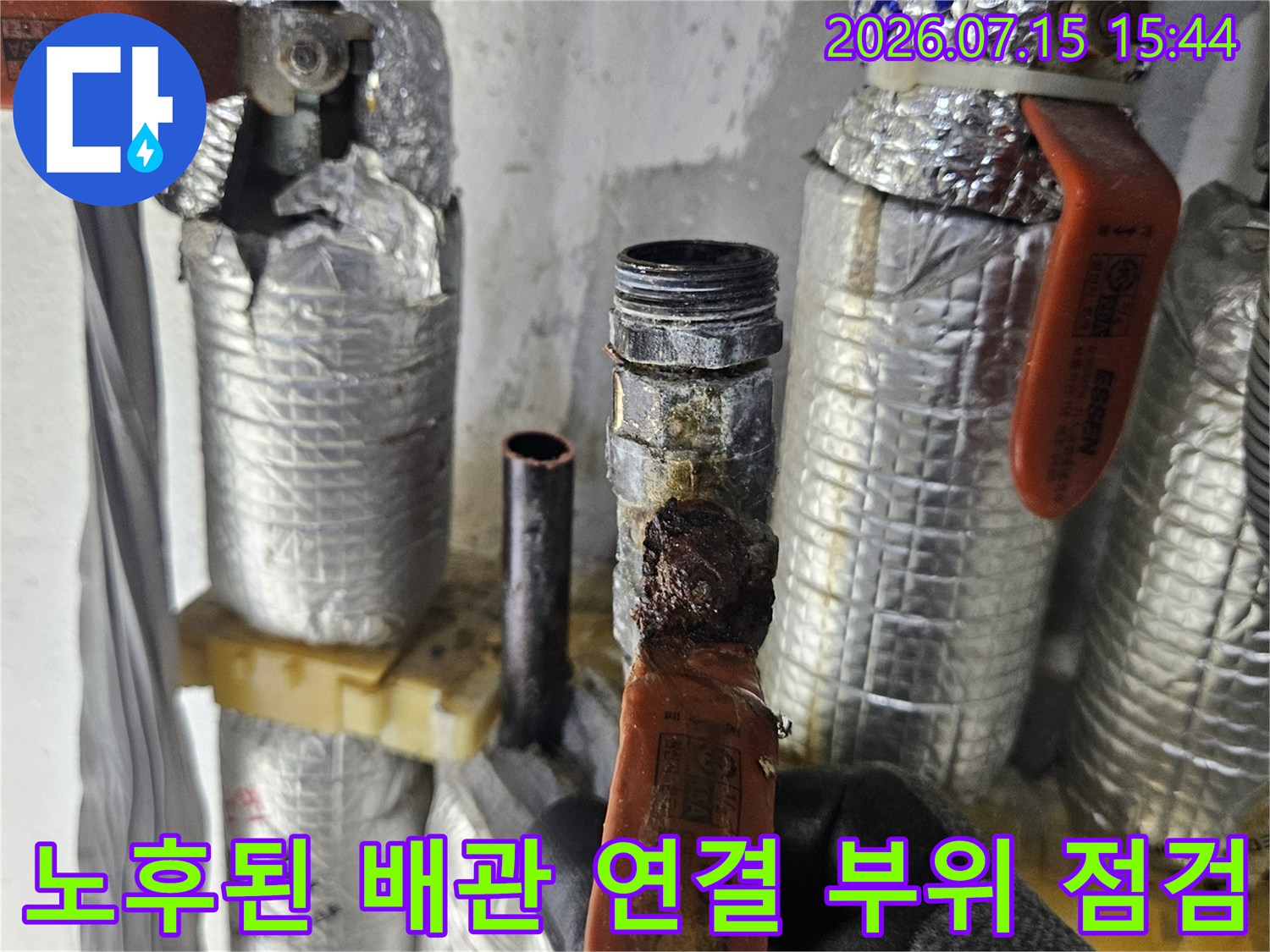 부식되어 노출된 세면대 하부 온수 배관과 은박 마감재로 감싸인 배관들
