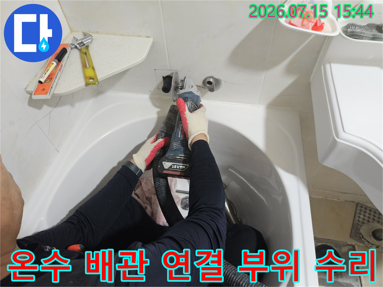 전문가가 세면대 아래 위치한 온수 배관의 노후된 연결부를 교체하는 사진