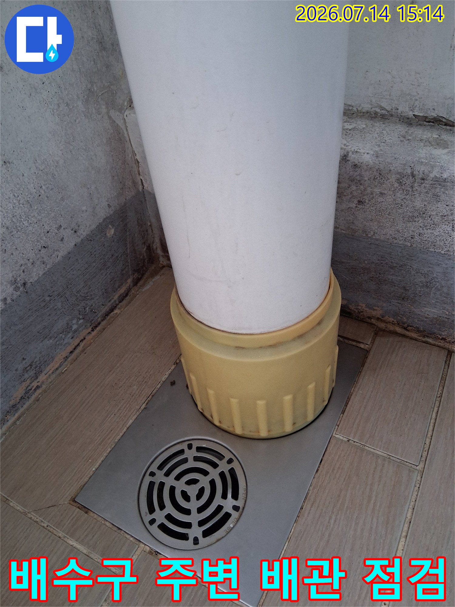 배수구와 연결된 흰색 배관 및 노란색 보호관 상세 사진