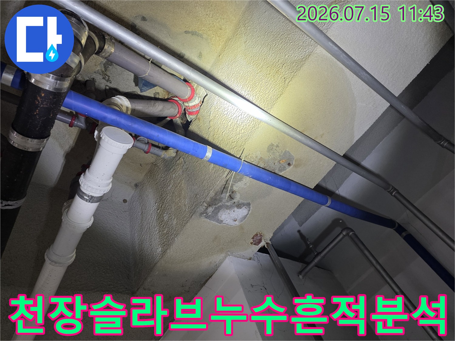 노란색-물자국이-넓게-퍼진-천장과-그-사이의-파란색-배관들