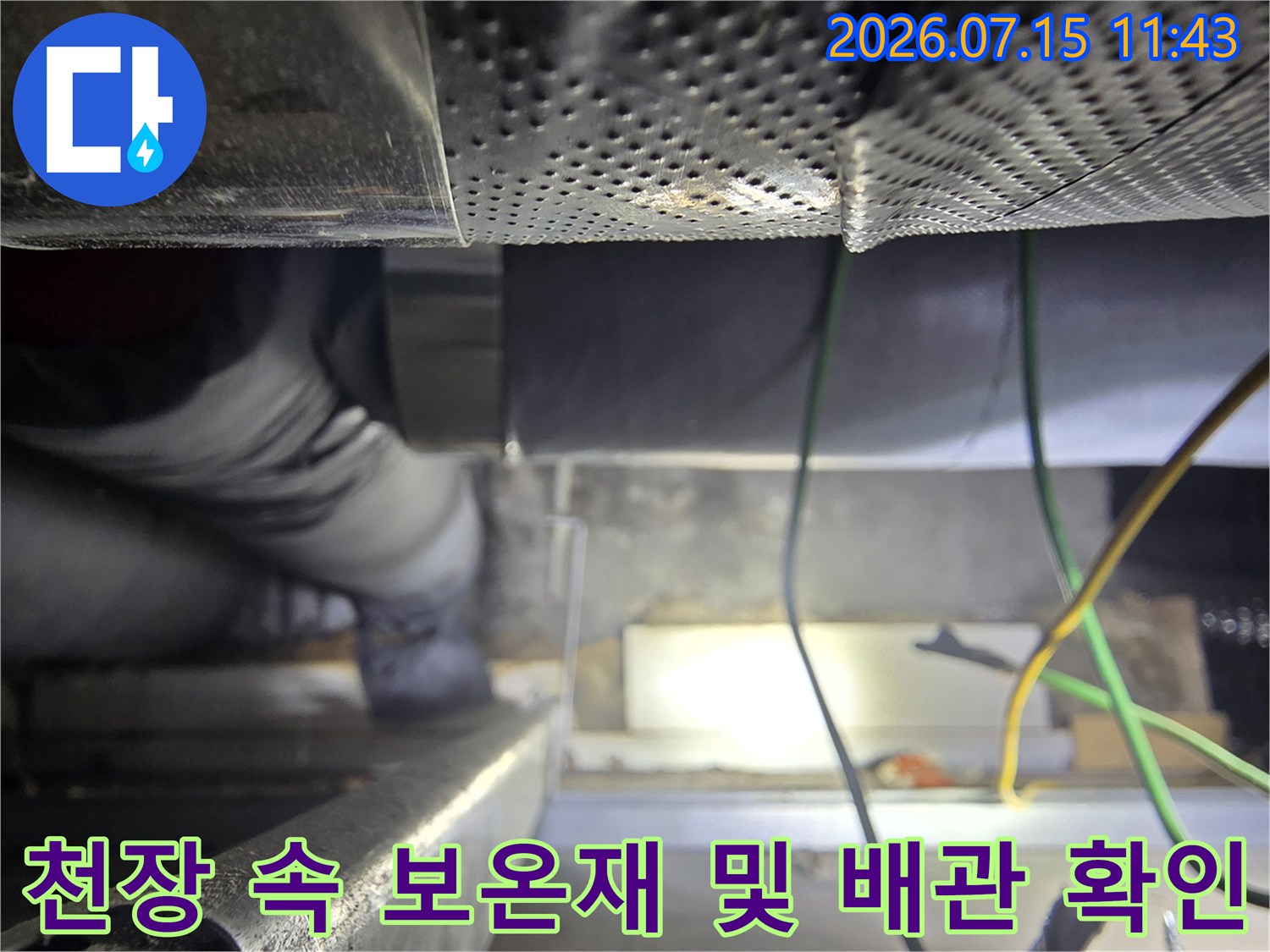 작업자가-천장의 좁은 공간에 들어가서-배관의 보온 마감 상태를 살피는 모습
