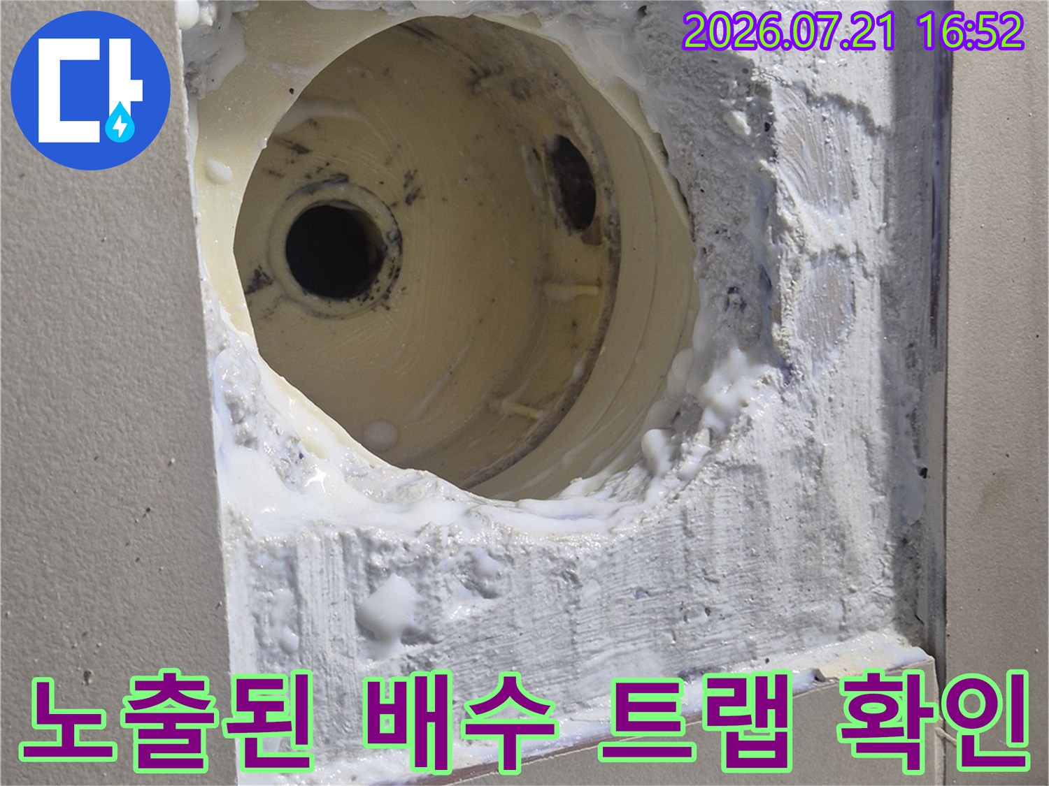 타일 제거 후 드러난 하얀 석회 덩어리와 배관 연결 부위를 촬영한 사진