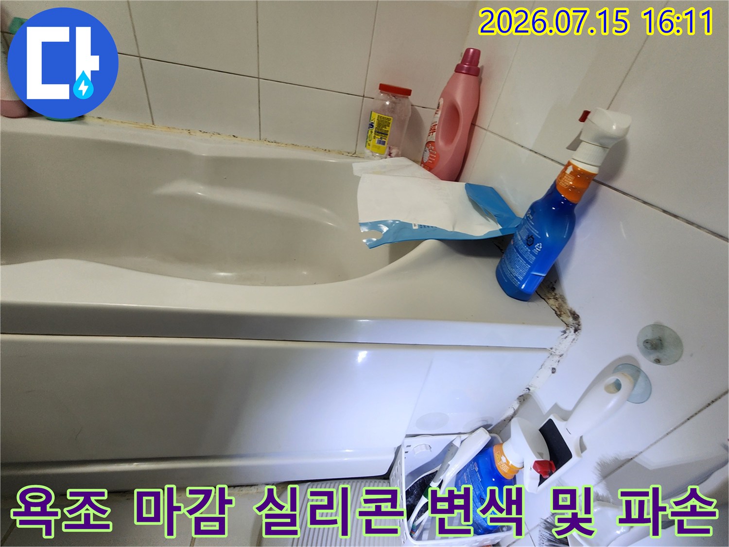 흰색 타일과 욕조가 만나는 지점에 검은 곰팡이가 심하게 피고 실리콘이 갈라진 상태