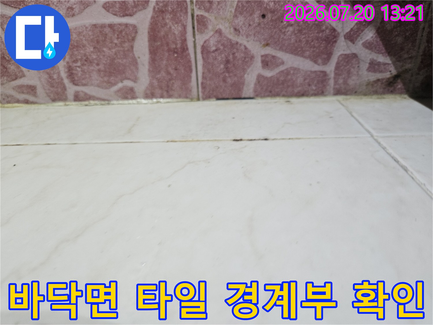 바닥 타일과 벽체 연결 부위의 줄눈 상태를 근접 촬영한 사진
