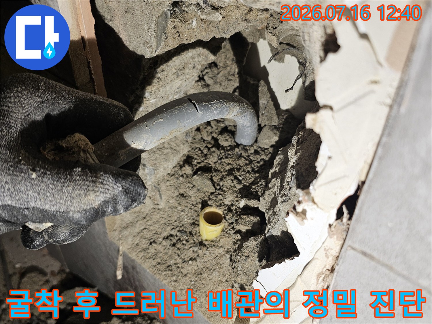 타일 파손 부위 내부에 노출된 관을 세밀하게 점검하는 장면