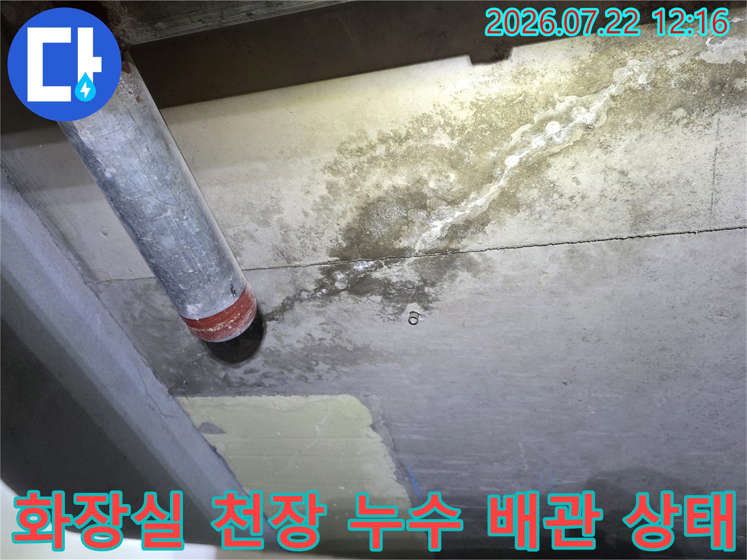 금속 배관 끝부분과 그 주변 콘크리트 천장에 형성된 습기 및 백화 자국
