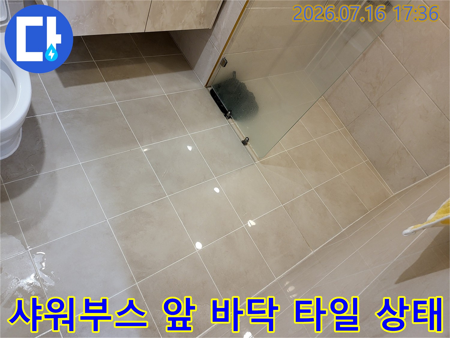 대형 타일이 시공된 샤워실 내부의 바닥면과 유리문 경계 부위