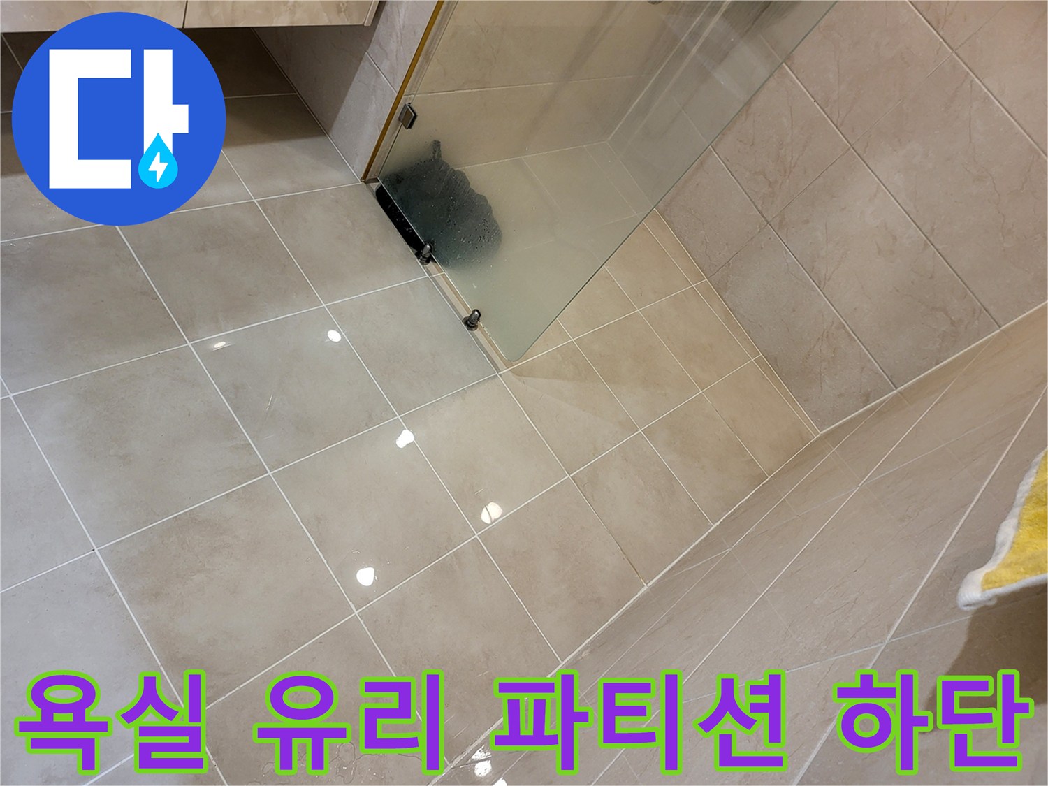 베이지색 타일과 샤워실 유리 파티션의 접합부