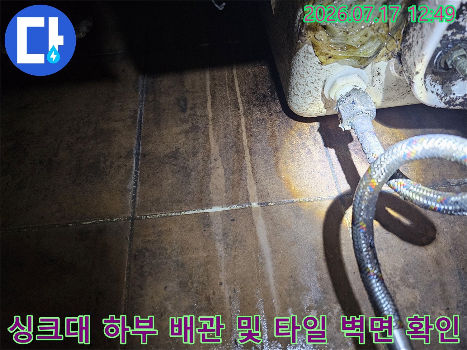 싱크대 아래쪽 수전과 연결된 호스 구간에 발생한 누수 흔적을 기록한 사진