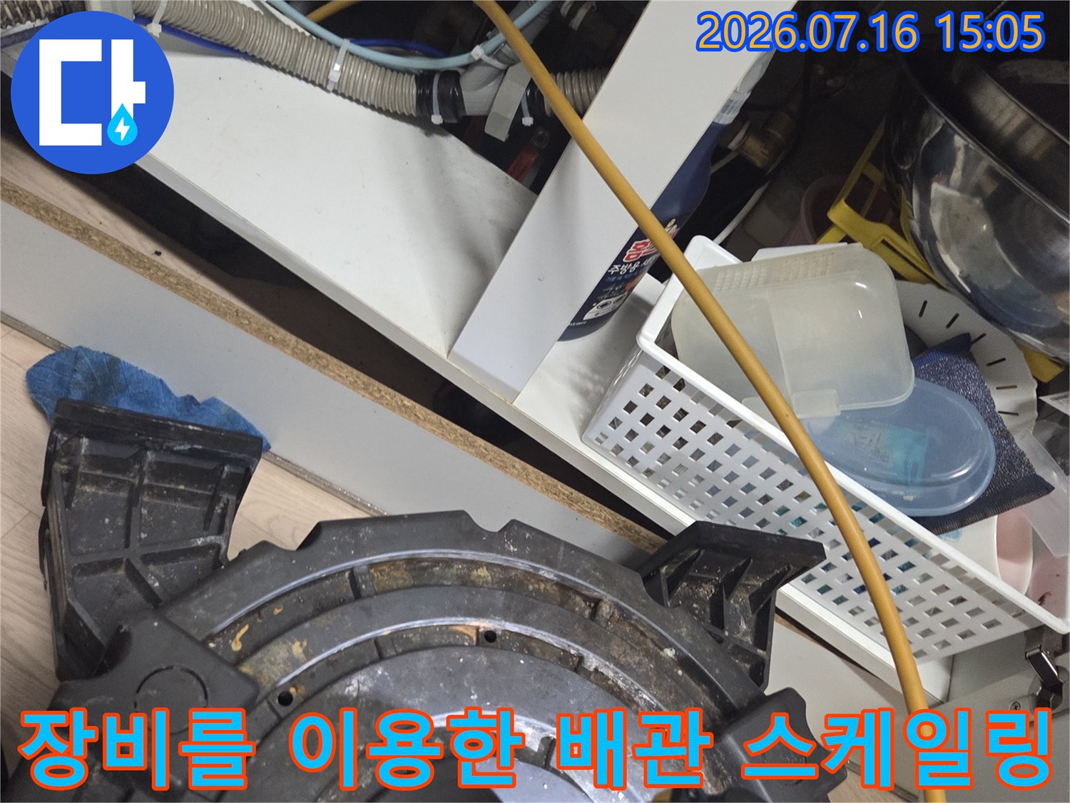 싱크대 하단부에서 샤프트 장비를 운용하여 배관 내 슬러지를 제거하는 모습