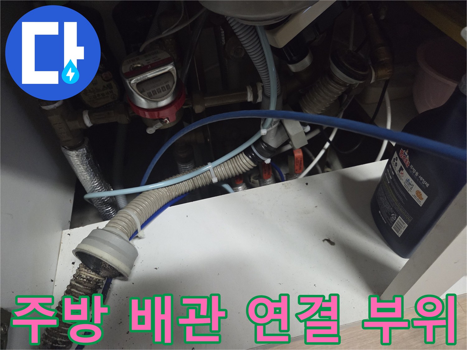 싱크대 하부 배수 호스와 급수 밸브가 연결된 배관 내부 사진