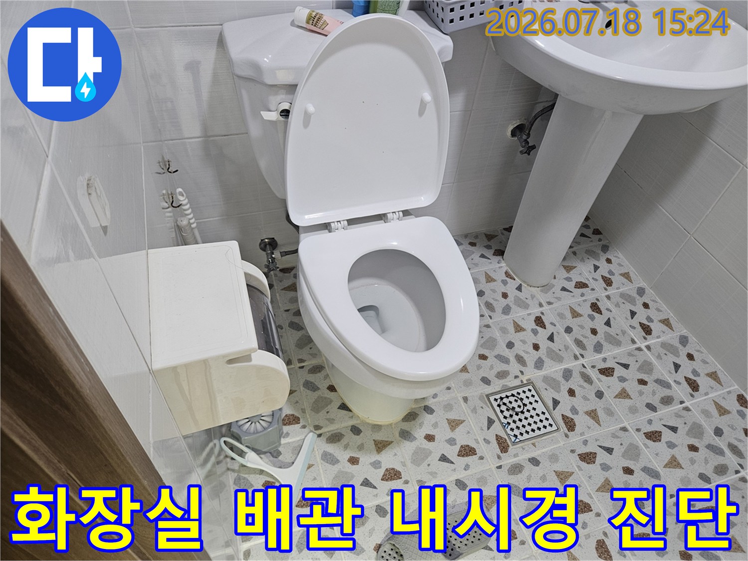 화장실 변기 옆 공간에서 확인한 노출된 배관과 내부 점검용 장비