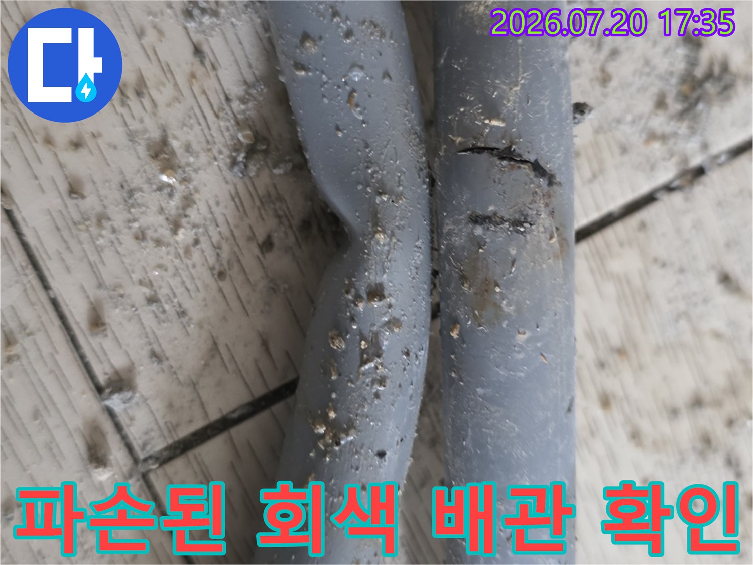 균열이 발생한 회색 배관의 파손 부위를 근접 촬영한 모습