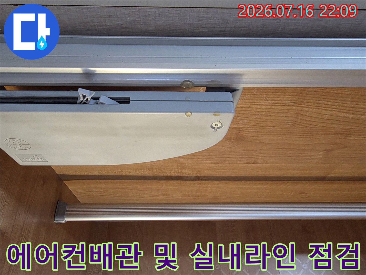 베란다 내부에 노출된 에어컨 배관과 금속 마감재를 점검하는 모습