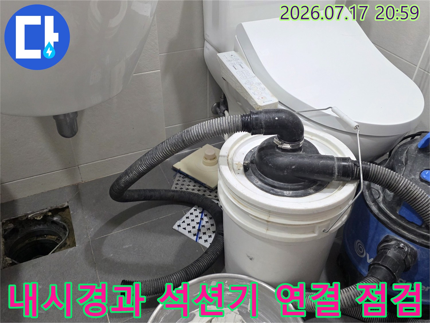 화장실 배수구 근처에서 내시경 호스와 석션기를 배치하여 내부를 정밀 조사하는 모습