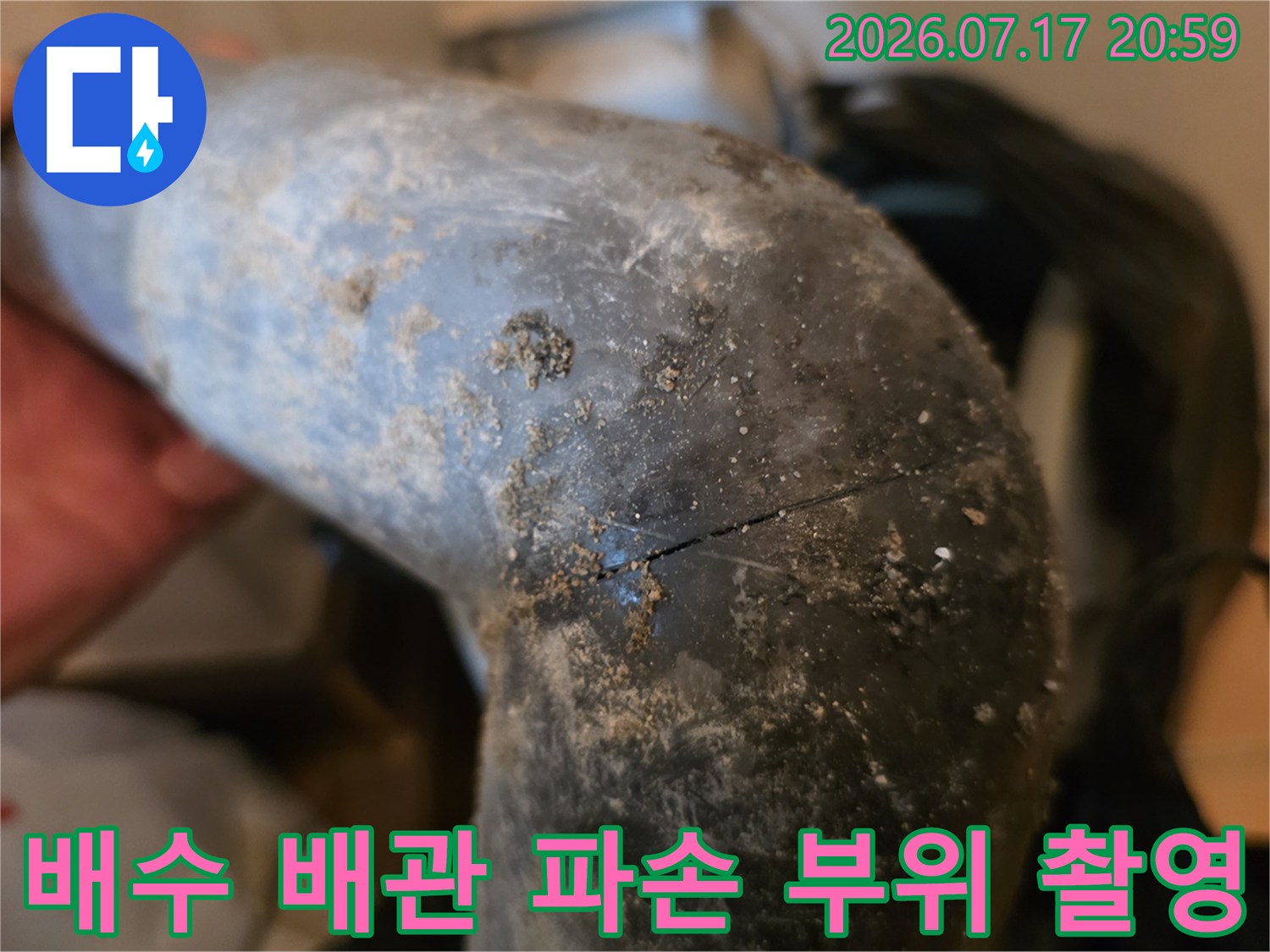 회색 배관 표면에 발생한 균열과 오염이 섞인 모습