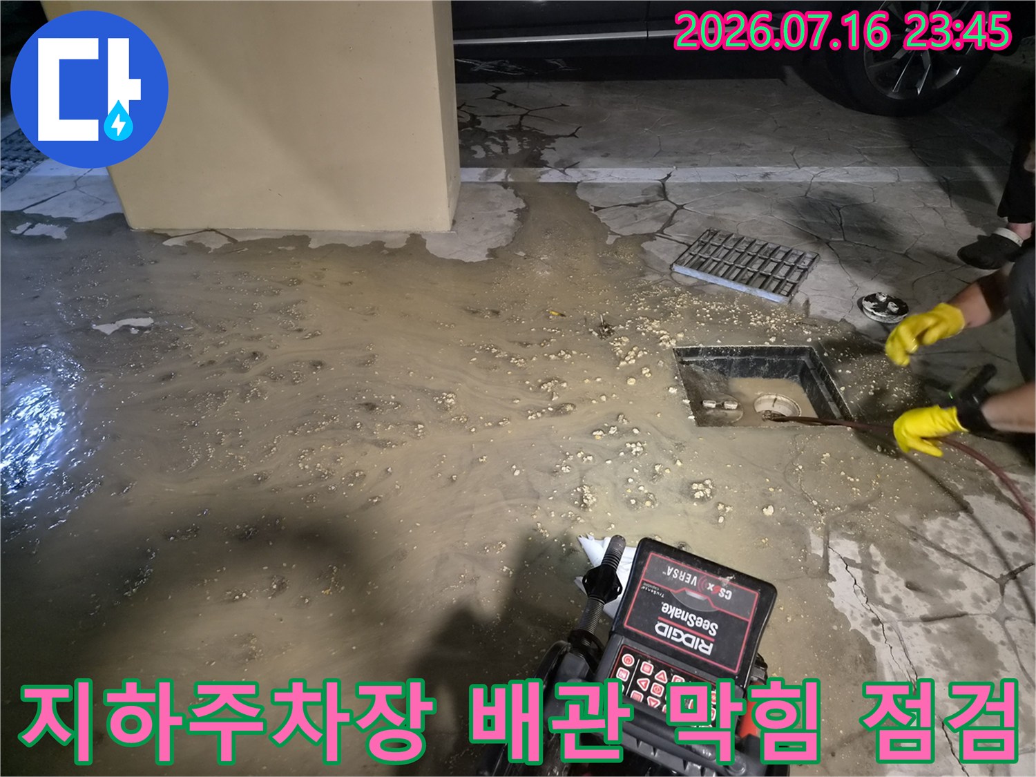 지하 주차장 바닥에 고인 오수와 장비를 이용해 배관을 점검하는 모습