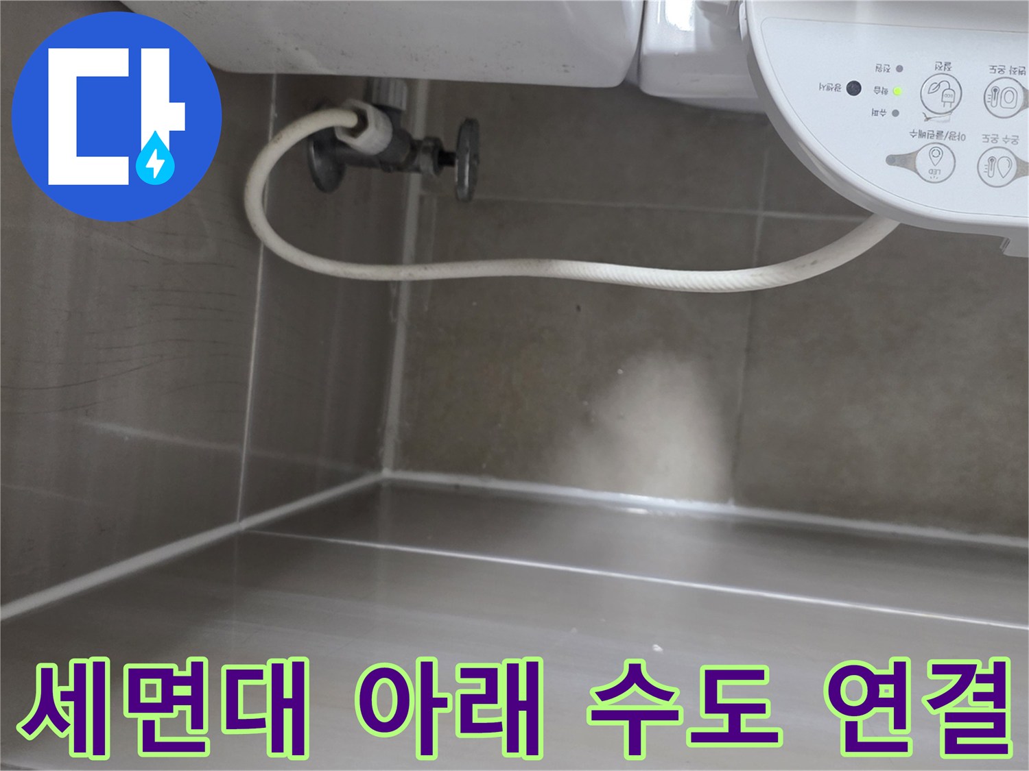 세면대 하단의 급수 밸브와 흰색 호스가 연결된 모습입니다.