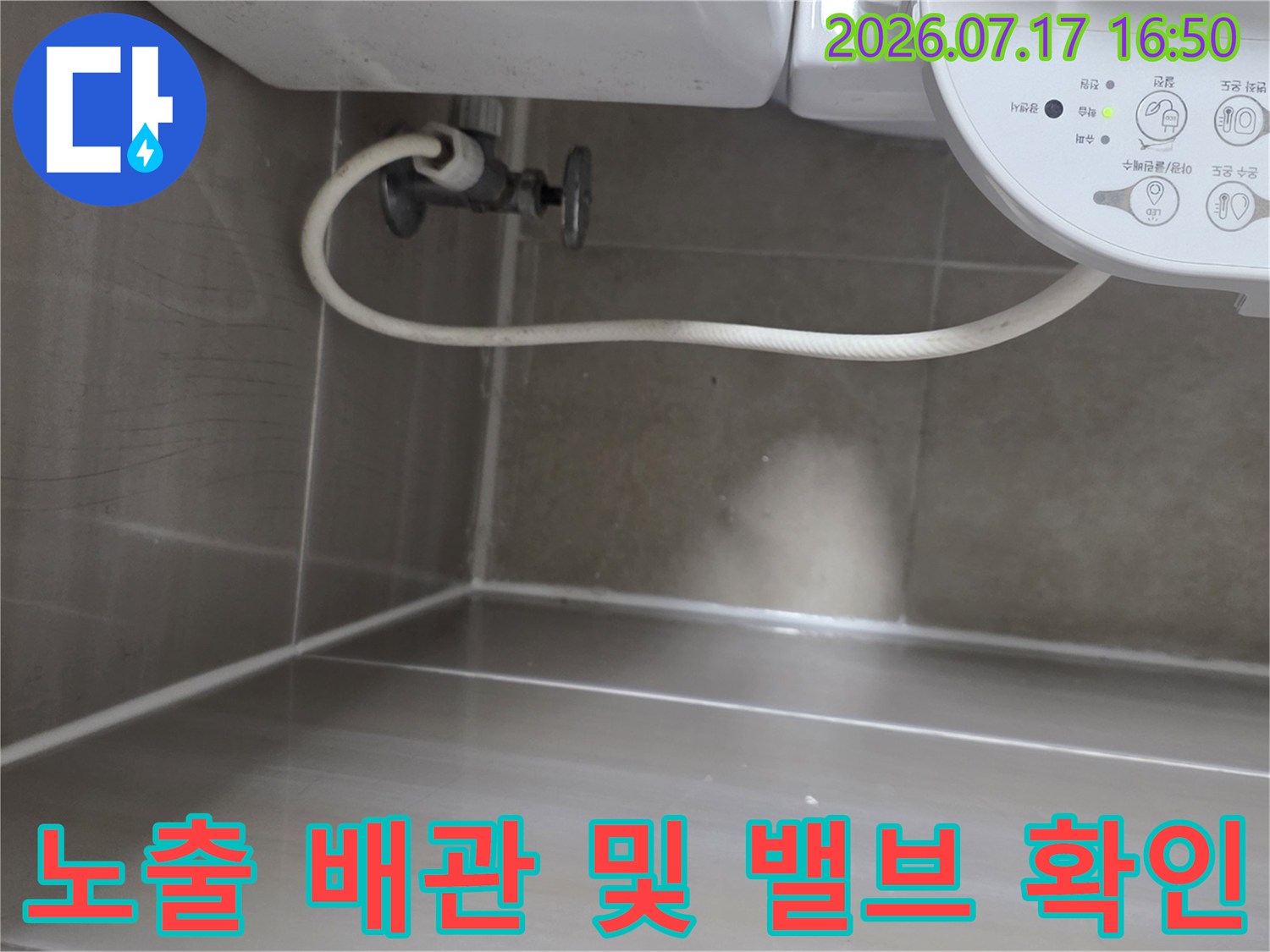 화장실 내부에 노출된 수도 배관과 연결 부위의 상태 점검 장면