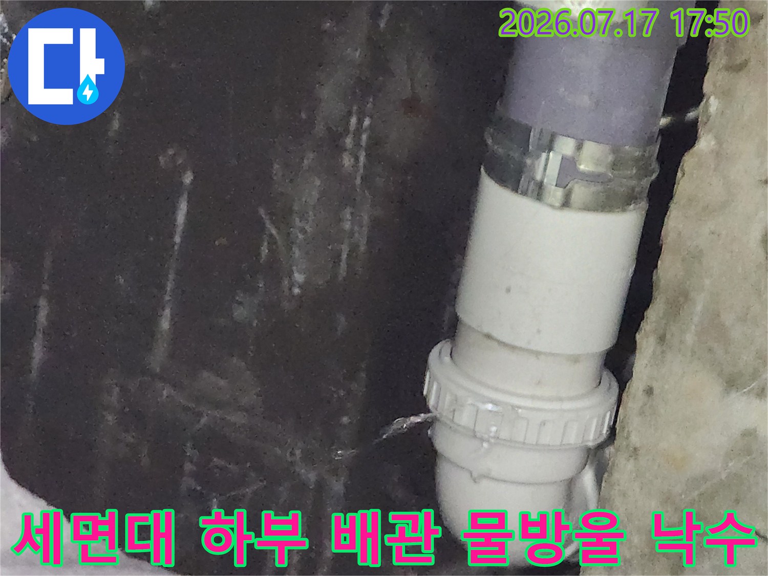 배수관 연결 캡 부근에서 아래로 물이 떨어지고 있는 근접 사진