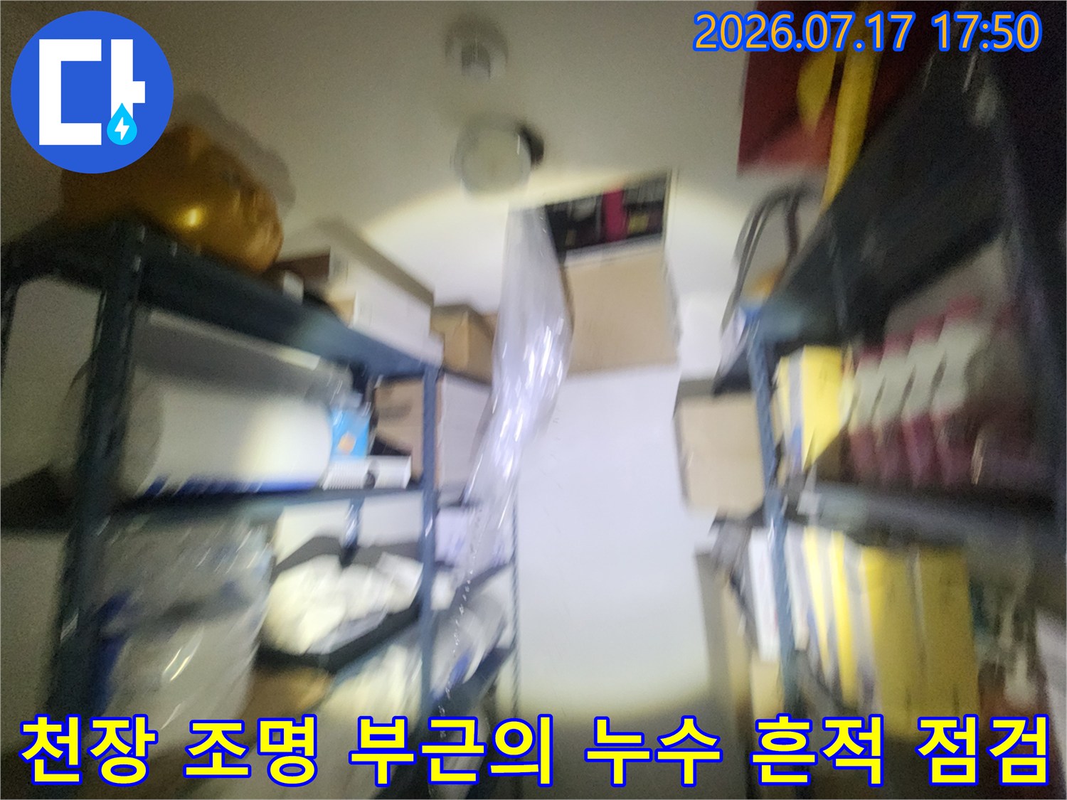 창고 내부 천장의-조명 기구와 배관 주변 모습 사진