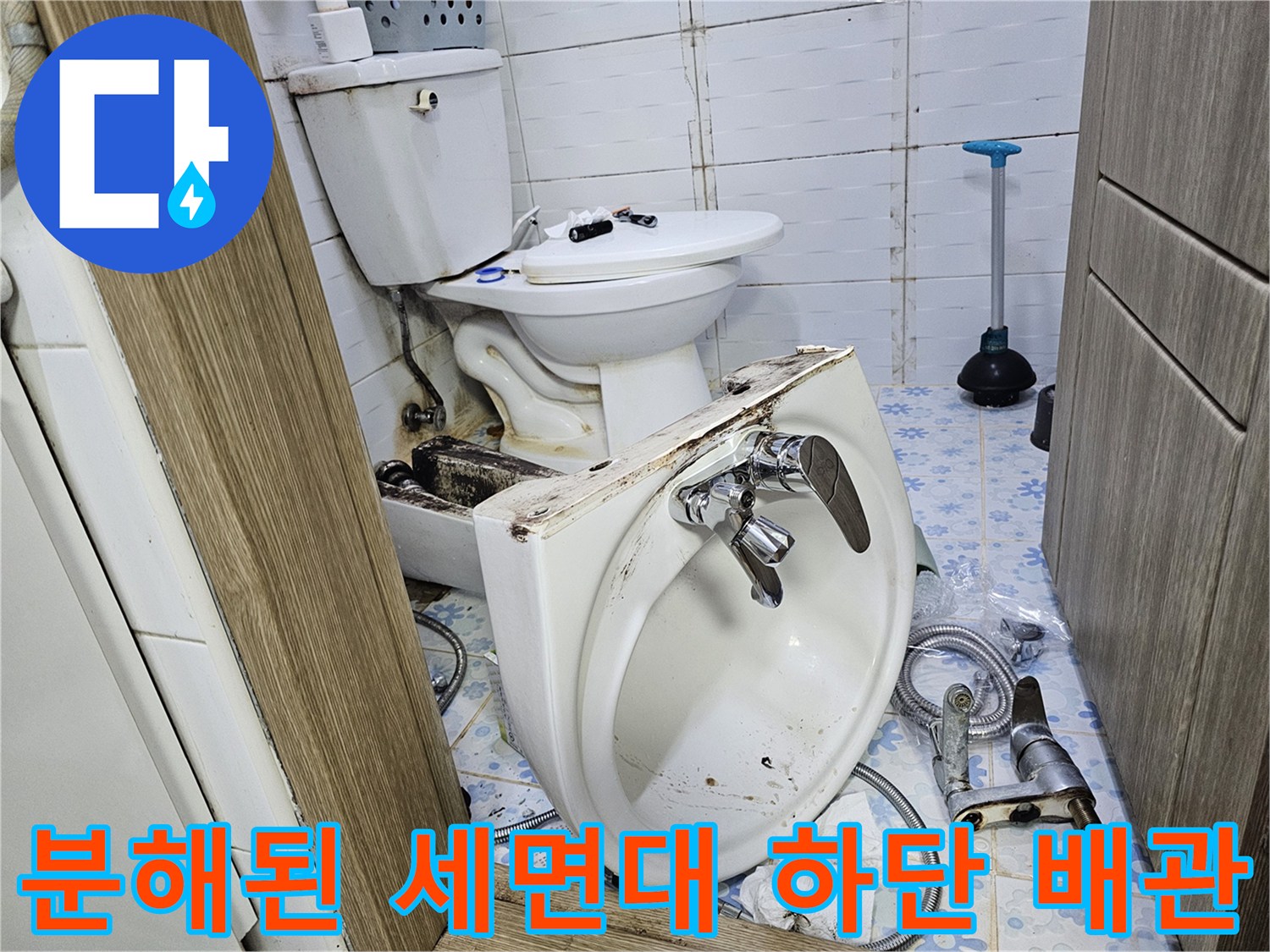 세면대가 분리되어 앵글밸브와 변기 부속이 드러난 화장실 내부입니다.