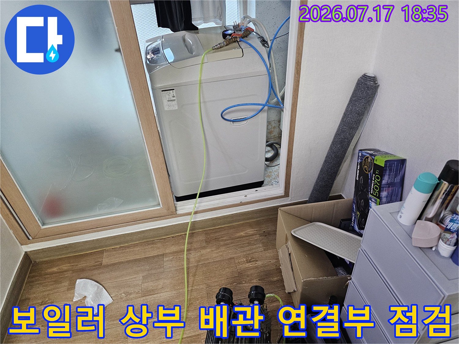 흰색 보일러 기기와 파란색 수도 호스-배관 연결 상태 촬영 사진