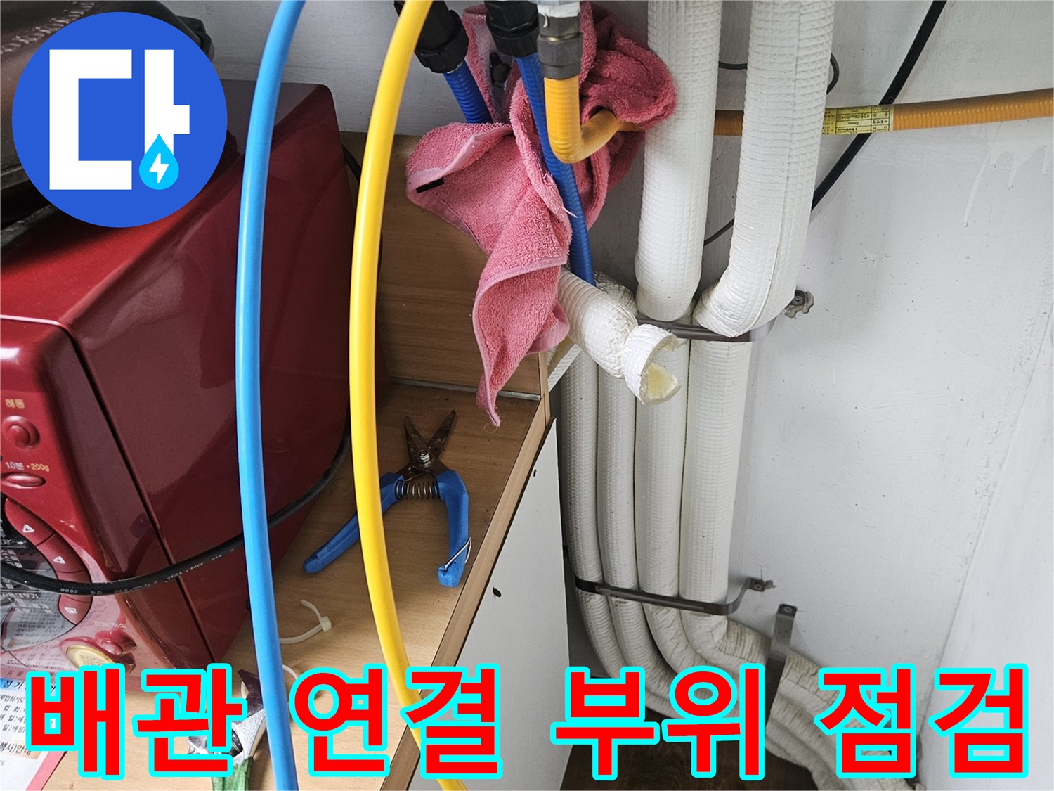 보일러 하부의 노란색 호스와 파란색 호스 연결 상태를 촬영한 사진입니다.