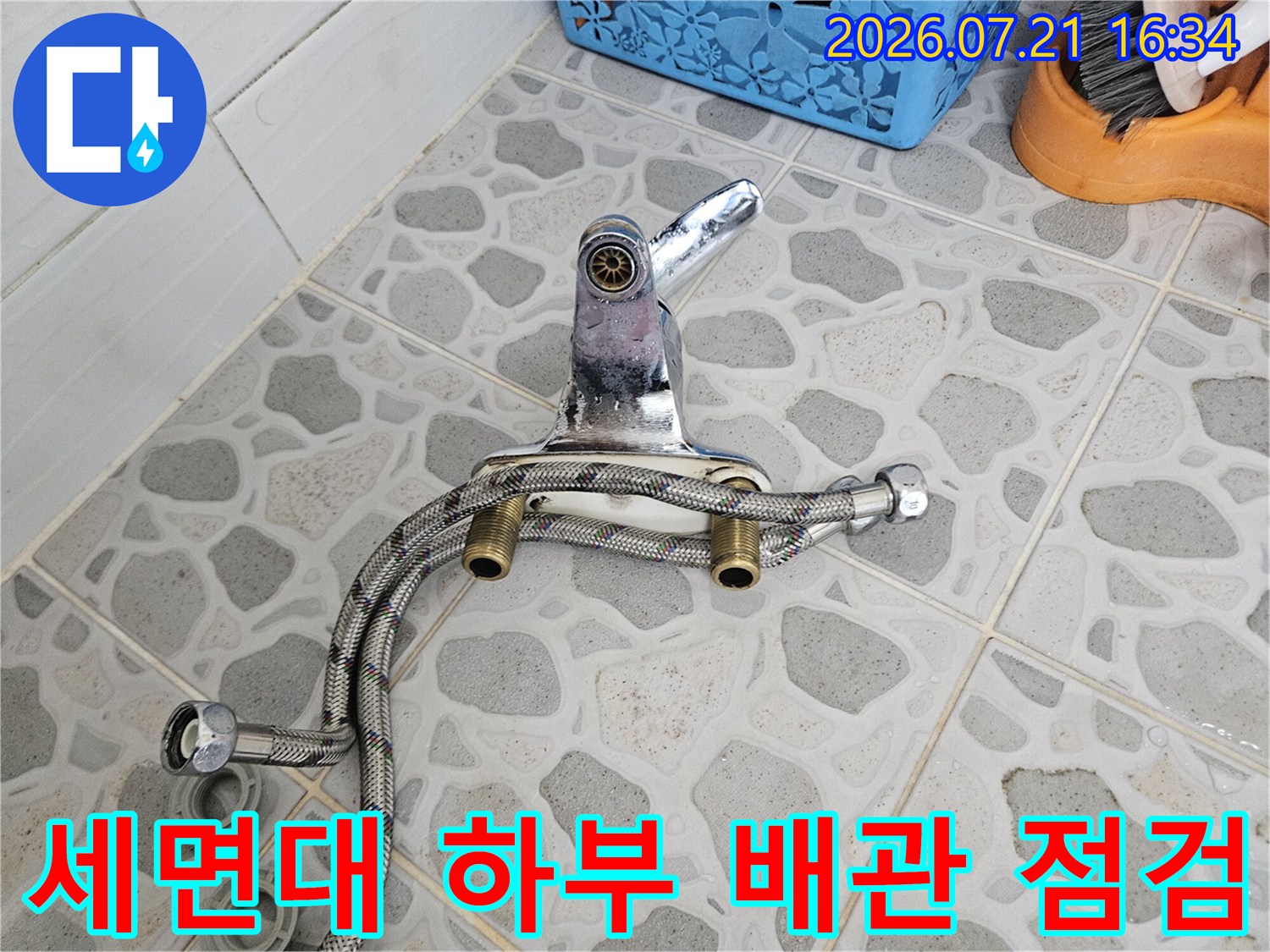 세면대 아래쪽으로 연결된 노출형 은색 배관과 밸브 및 수전 부품의 상세 상태를 확인하는 모습