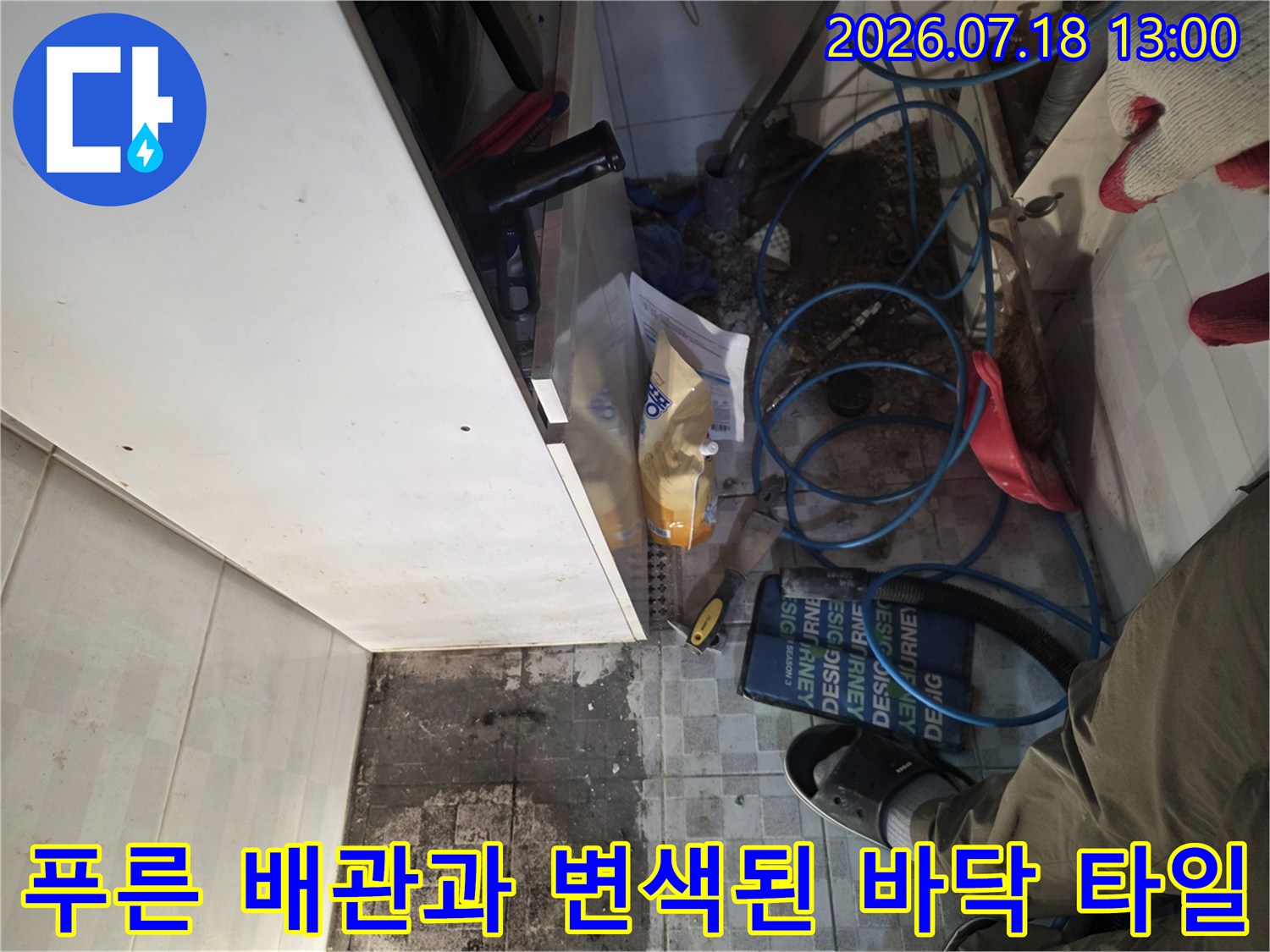 싱크대 하단 파란색 배관들과 물에 젖어 얼룩진 타일-누수 지점 분석