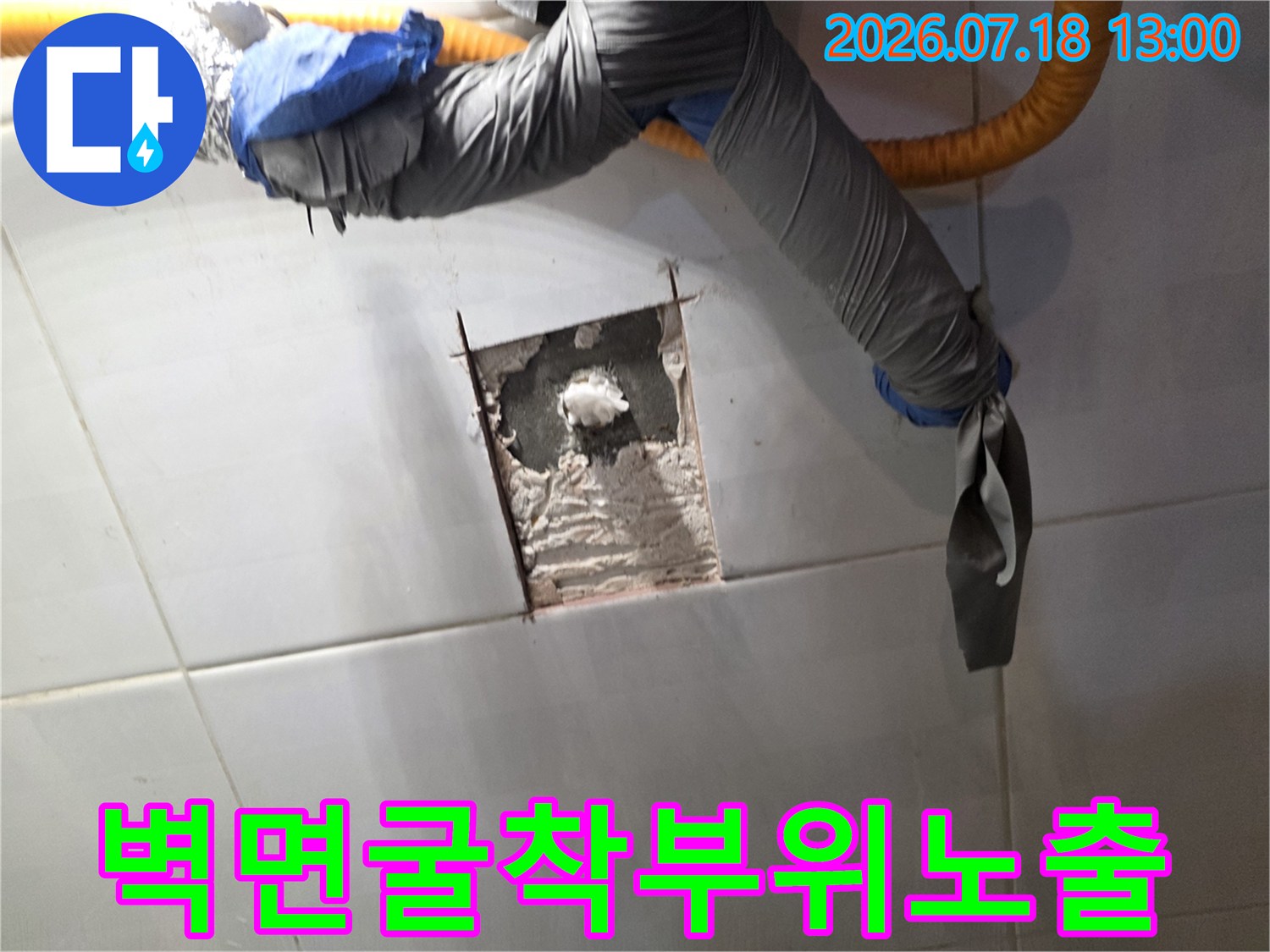 회색-보온재로-감싸진-배관과-타일이-제거된-벽면-틈새