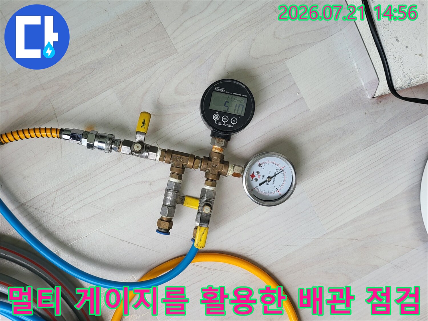 온수 배관 시스템에 연결된 여러 개의 호스와 압력계로 정밀 진단을 실시하는 장면