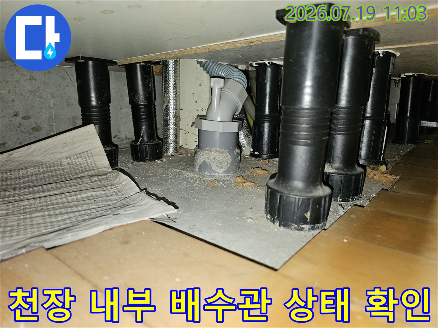 회색의-드레인 관과-검은색 지지 구조물이-설치된 천장 속 모습