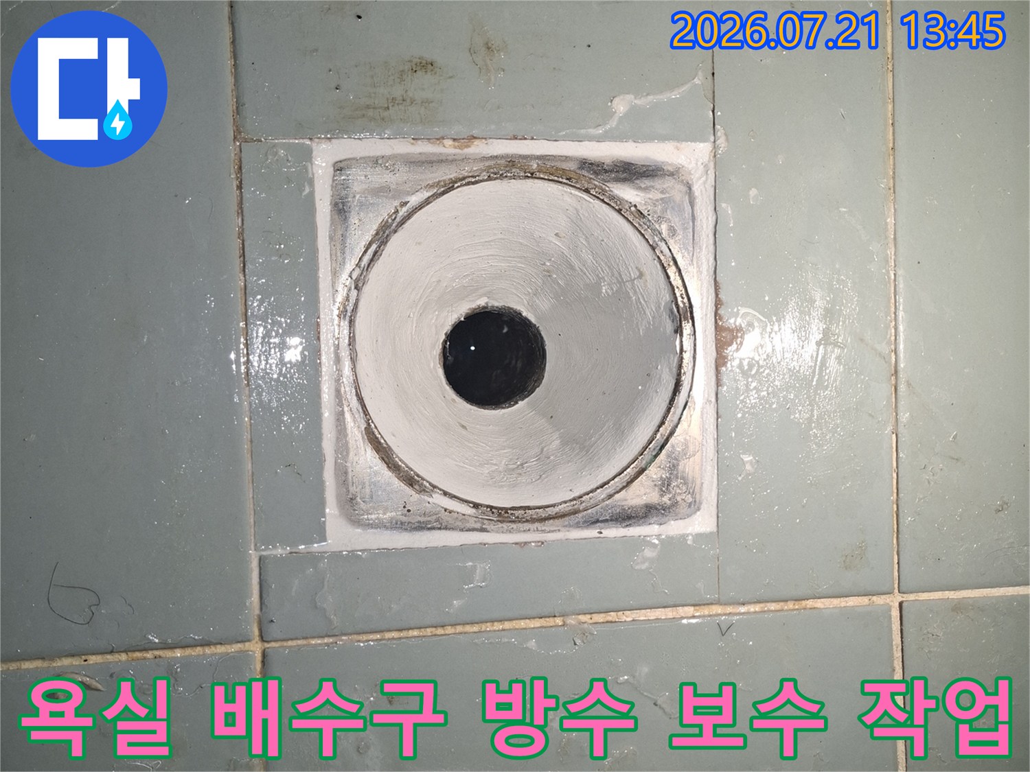 거친 질감의 타일과 회색 시멘트로 마감된 욕실 배수구 주변의 누수 방지 처리 모습