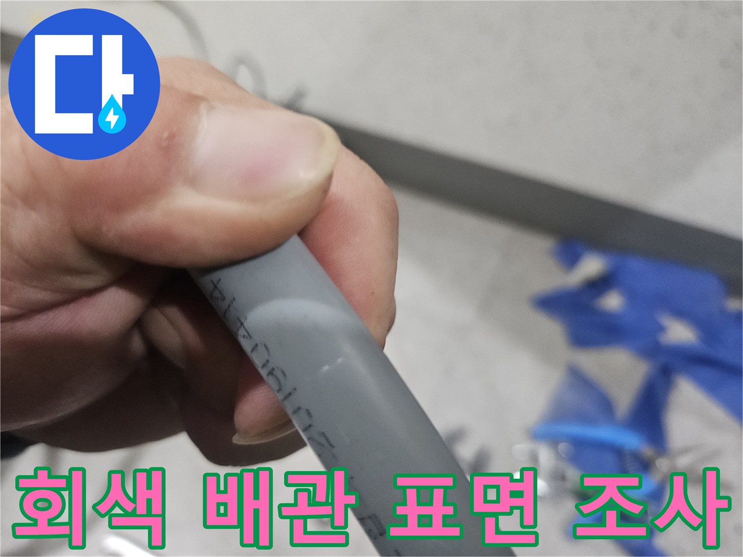 손가락으로 배관을 짚으며 검사하는 사진-배관 점검 현장